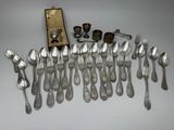 a lot of silver spoons and silverware on a table