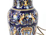 a blue and gold vase with a lamp on it