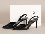 une paire de chaussures noires à talons hauts, avec une boîte en arrière-plan