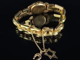a close up of a gold bracelet with a watch on it
