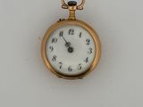 a gold pocket watch with a white face on a white surface