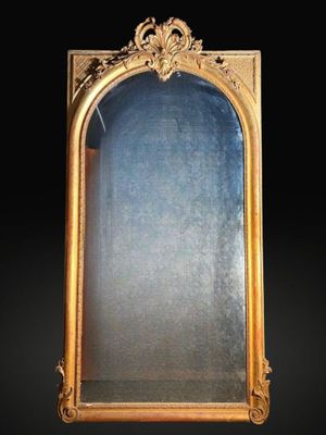 Très important miroir en bois sculpté, stuqué et doré à fron…