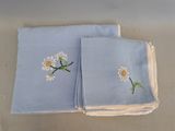 deux serviettes bleues ornées de marguerites, posées sur une table