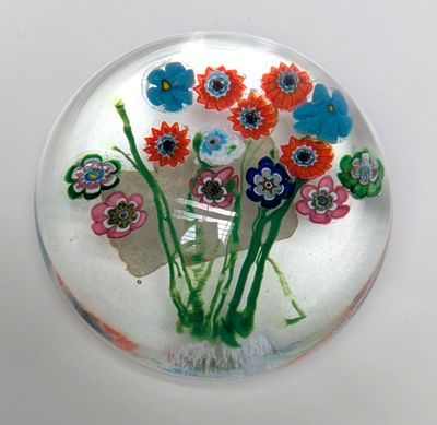 une assiette en verre contenant des fleurs, posée sur une table