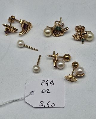 several pairs of pearl and gold earrings and a price tag