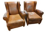pair of brown leather recliners with matching foot stools
