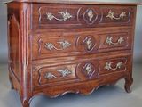 a wooden chest of drawers with gold decorations on it