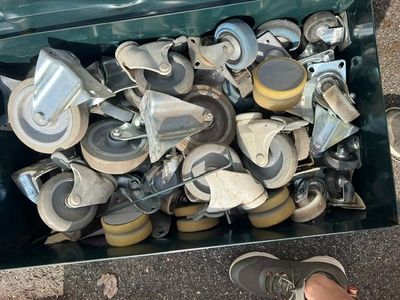 une valise pleine de roulettes, avec une personne debout à côté