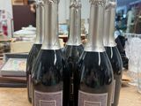 trois bouteilles de vin posées sur une table en bois