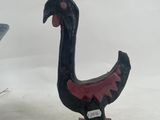 a black and red bird statue next to a blue and white vase