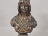 un buste antique en bronze représentant une femme coiffée d'un chapeau