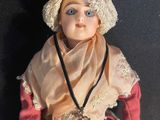 a doll that is wearing a skirt and a hat