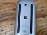 an apple computer mouse sitting on top of a wooden table
