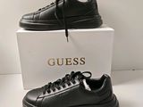 black leather sneakers with a gold logo on the side