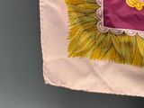 a pink bag with yellow fringes hanging on a wall