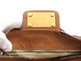 the inside of a brown purse with a white glove on top of it