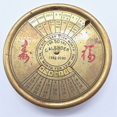 une horloge dorée, ornée d'inscriptions en chinois sur un fond blanc