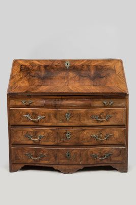 an antique walnut bureau with brass handles