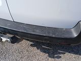 rear end of a white car with a black bumper on it