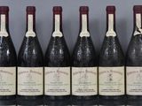 six bouteilles de vin sont alignées sur une table