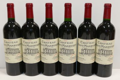 six bouteilles de vin rouge sont alignées sur une table
