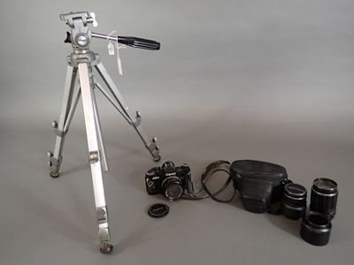 a tripod with a camera and other items on a table