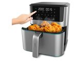 an air fryer with fried chicken in it and a hand pointing to it