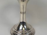 a silver candle holder with a candle on top of it