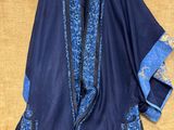 une veste bleue et noire avec des bordures bleues sur fond beige clair