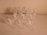 seven wine glasses sitting on a table with a white background