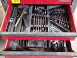 a red tool box with tools in it in a garage