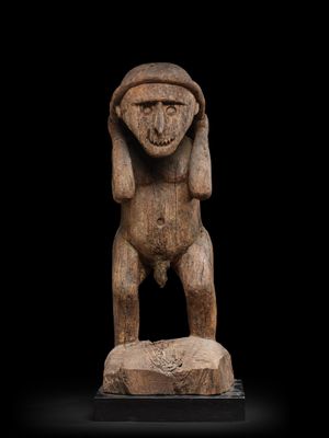 une statue en bois d'un homme avec un chapeau sur la tête