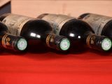 several bottles of wine are lined up on a red cloth