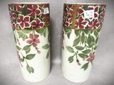 deux vases décorés de fleurs posés sur une table