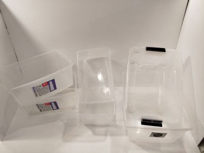 three plastic containers that are sitting on the floor