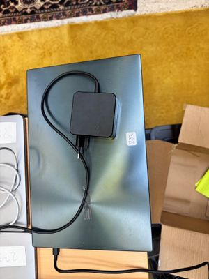 un ordinateur portable posé sur une table, avec son chargeur