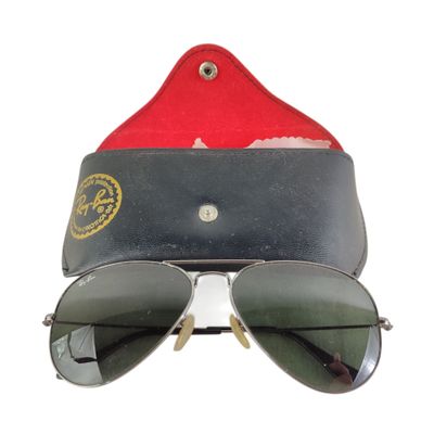 une paire de lunettes de soleil avec un étui rouge et un chapeau rouge sur fond blanc