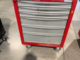 une boîte à outils rouge posée sur un chariot métallique