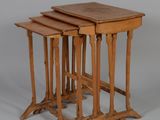 trois tables gigognes en bois empilées les unes sur les autres sur une surface grise