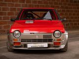 a red car that is parked in front of a brick wall