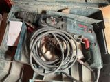 un outil dans une boîte, muni d'un cordon et d'une perceuse
