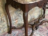 une petite table au plateau en marbre posée sur un tapis