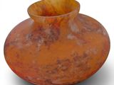 a large orange vase sitting on a white surface