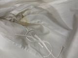 a white bed with a white comforter and a white pillow