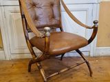 un fauteuil en cuir marron placé devant une porte blanche