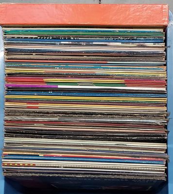 une pile de disques vinyles posée sur une table bleue