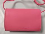 a close up of a pink purse on a white surface