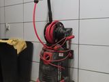 une photo d'un aspirateur rouge et noir dans une salle de bains