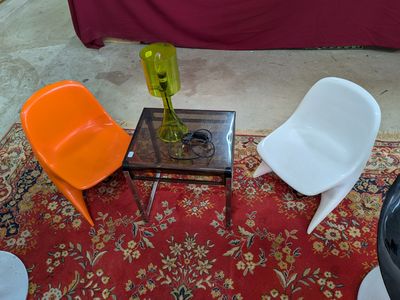 trois chaises et une table sur laquelle se trouve un vase