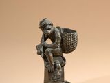 bronze figurine of a man with a basket on his head